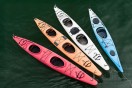 four colorful fiberglass kayaks