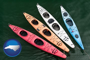 four colorful fiberglass kayaks - with North Carolina icon